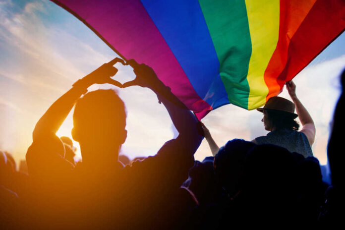 Pride,Community,At,A,Parade,With,Hands,Raised,And,The