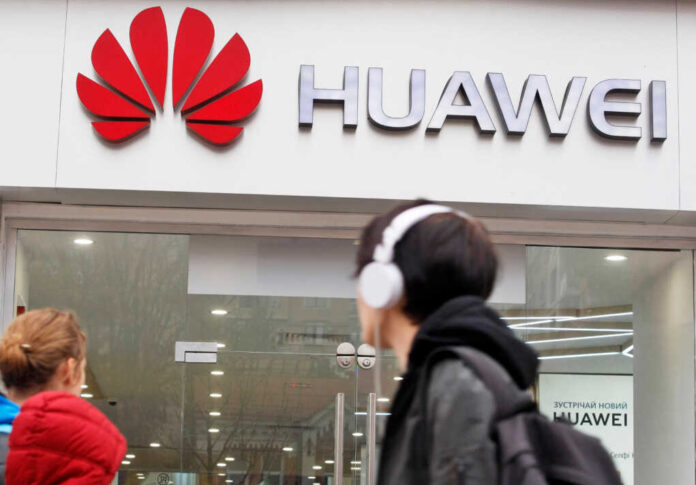 People,Walk,Past,Of,A,Huawei,Brand,Store,In,Kiev,