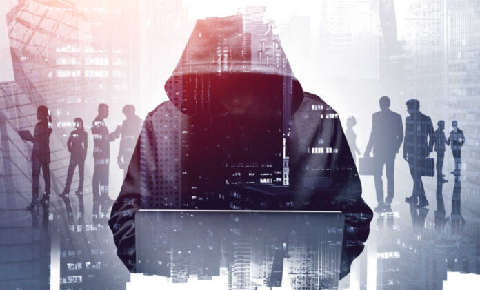Unrecognizable,Young,Hacker,In,Hoodie,Using,Laptop,In,Blurry,City.