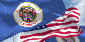 Minnesota state flag in front of American flags