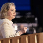 A woman speaking at a podium with a microphone during a public event