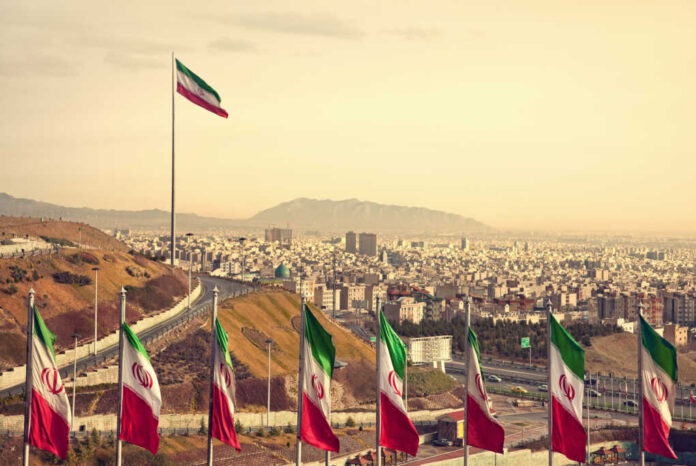Set,Of,Iran,Flags,In,Front,Of,Tehran,Skyline,And