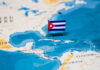 A small Cuban flag placed on a map highlighting Cuba in the Caribbean