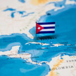 A small Cuban flag placed on a map highlighting Cuba in the Caribbean