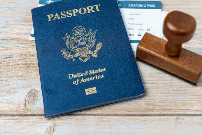 shutterstock_2263234505.jpg A U.S. passport, boarding pass, and a wooden stamp on a wooden surface