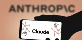 A hand holding a smartphone displaying the name 'Claude' with abstract graphics