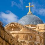 Dome of a church topped with a golden cross against a blue sky