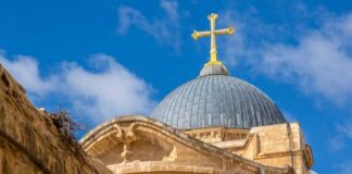 Dome of a church topped with a golden cross against a blue sky