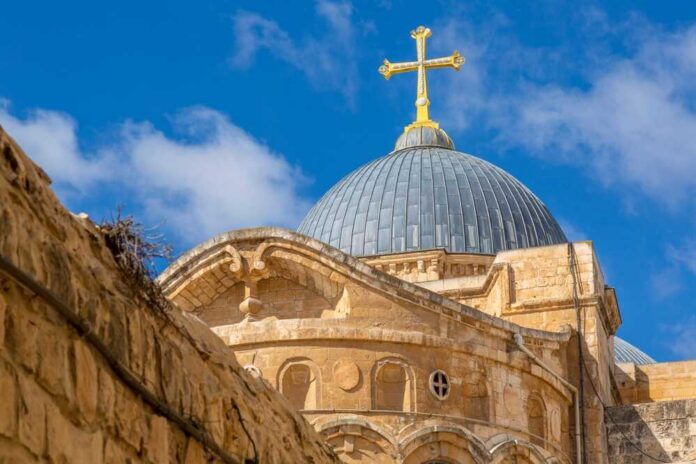 Dome of a church topped with a golden cross against a blue sky