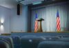Empty auditorium with a podium and American flags