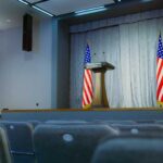 Empty auditorium with a podium and American flags
