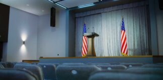 Empty auditorium with a podium and American flags