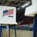 Voting booths with American flags set up in a gymnasium