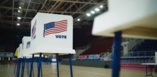 Voting booths with American flags set up in a gymnasium