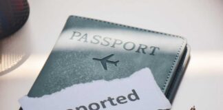 A passport with a note that reads 'Deported' placed beside a pen