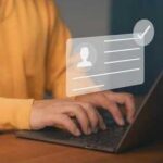 Person typing on a laptop with a digital identity verification graphic