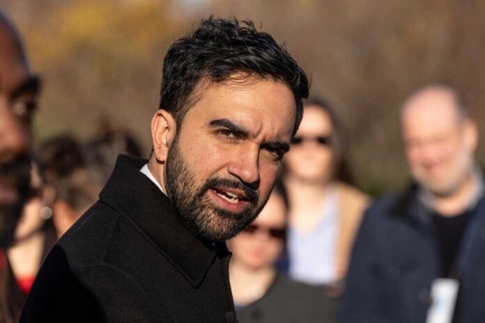 A man speaking passionately at an outdoor event with an engaged audience in the background