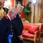 Two men in formal attire walking through a lavishly decorated room