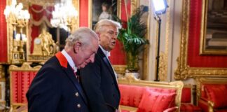 Two men in formal attire walking through a lavishly decorated room