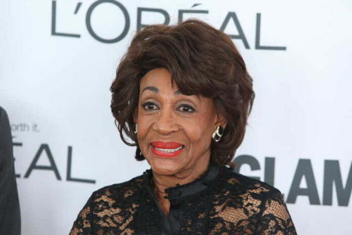 A woman in elegant black attire smiling at a celebrity event