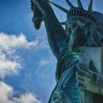 Close-up view of the Statue of Liberty against a blue sky