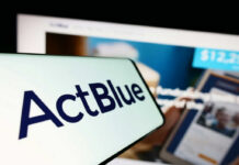 Close-up of ActBlue logo on a mobile device with a website in the background
