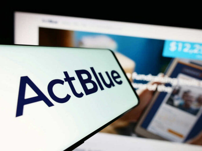 Close-up of ActBlue logo on a mobile device with a website in the background