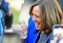 A woman smiling and engaging with a crowd at an outdoor event