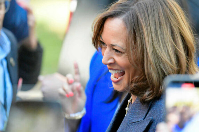 A woman smiling and engaging with a crowd at an outdoor event