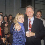 A couple posing together at a public event with a crowd in the background