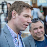 Two men engaged in conversation at an outdoor event