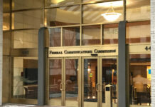 Entrance of the Federal Communications Commission building with glass doors and signage
