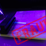 A passport under UV light with a stamp indicating fraud