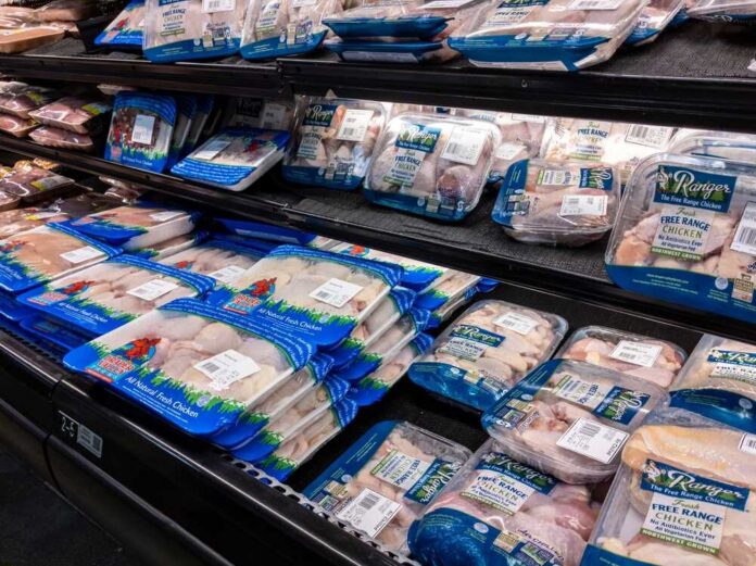 Shelves stocked with various packages of free range chicken