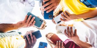 A group of friends holding smartphones in a circle, looking down at their devices