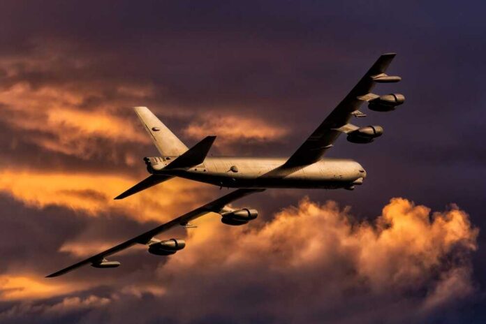 Military aircraft flying against a colorful sunset sky