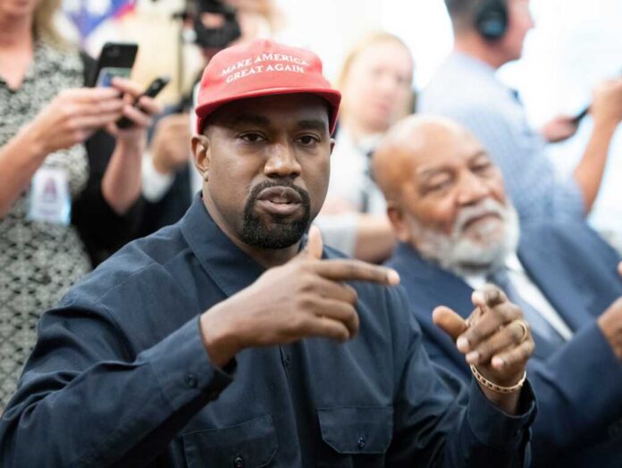 A man wearing a red cap gestures during a discussion at a political event