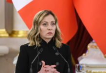 A political leader at a press conference with a serious expression