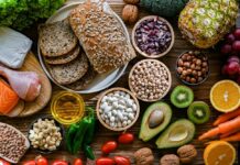 OUTRAGE: Misleading “Healthy Carb” Labels Exposed A variety of fresh foods including vegetables, fruits, grains, and proteins arranged on a wooden surface