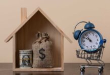 A wooden house model with money and a clock in a shopping cart
