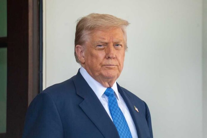 A man in a suit with a serious expression standing outdoors