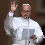 Religious leader giving a speech outdoors with a raised hand