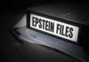 A black binder labeled 'Epstein Files' with papers and a pen beside it
