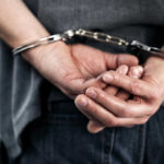 Hands cuffed behind the back, indicating arrest