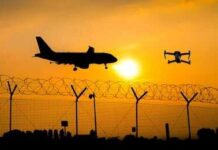 Air Defense Chaos: Moscow Under Siege! An airplane and a drone flying against a sunset backdrop with a barbed wire fence