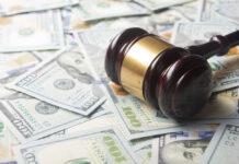 A gavel resting on a pile of hundred dollar bills