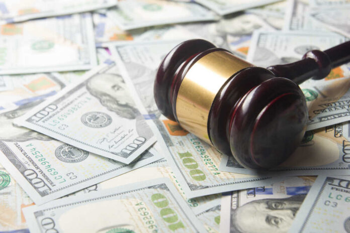 A gavel resting on a pile of hundred dollar bills