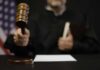 A judge holding a gavel in a courtroom setting