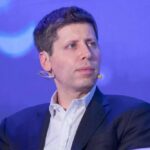 A man in a suit speaking at a conference with a microphone