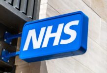 Massive NHS Reforms — Chaos and Confusion! NHS sign displayed prominently on a building